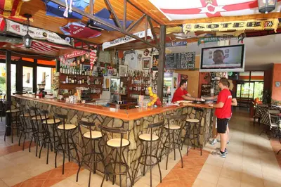 two people standing at a bar in a restaurant at Friends Family Hotel in Sunny Beach