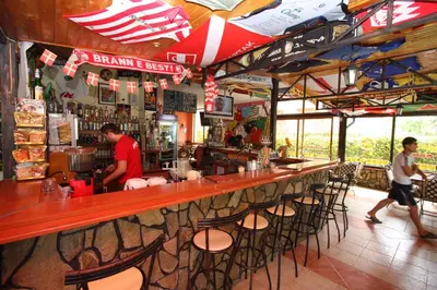 a bar in a restaurant with a man standing at the counter at Friends Family Hotel in Sunny Beach