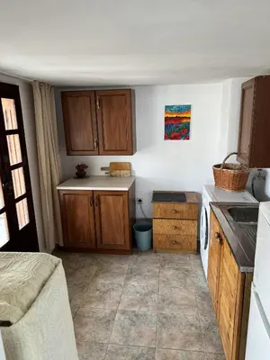 a small kitchen with wooden cabinets and a sink at obzor, orkinos in Obzor
