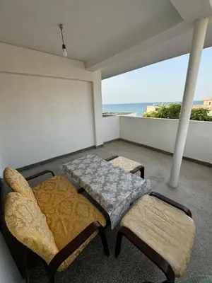a room with two beds and a balcony with the ocean at obzor, orkinos in Obzor