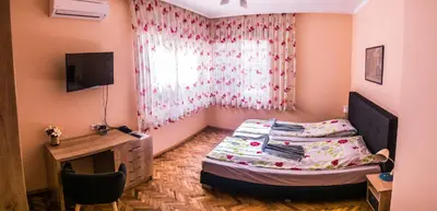 a bedroom with a bed and a desk and a window at Two Bedroom Apartment Downtown Ivanovi in Varna City