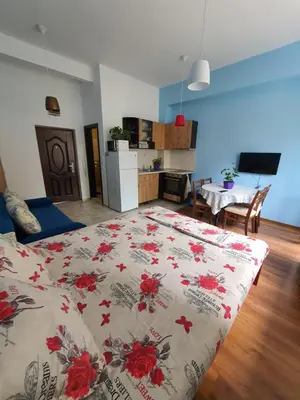 a bedroom with a bed and a kitchen with a table at Flowers Studio in Pomorie