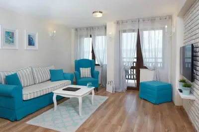 a living room with a couch and two blue chairs at Villa Elea in Nesebar