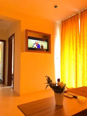 a living room with a television and a table with a plant at Sunny Paradise Family Hotel in Kiten