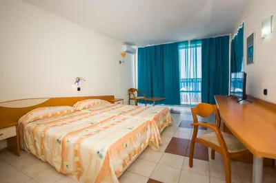 a bedroom with a bed and a desk and a table at Royal Bay Hotel - All Inclusive in Elenite