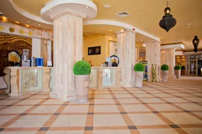 a lobby with columns and potted plants in a building at Royal Bay Hotel - All Inclusive in Elenite
