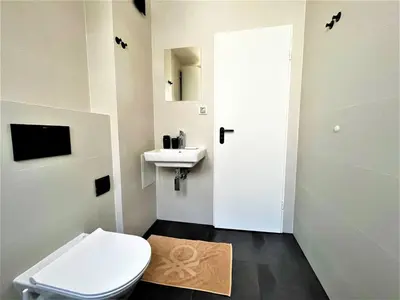 a white bathroom with a toilet and a sink at Bravo 5 Holiday Home in Sunny Beach