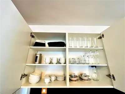 a kitchen cabinet filled with lots of dishes and utensils at Bravo 5 Holiday Home in Sunny Beach