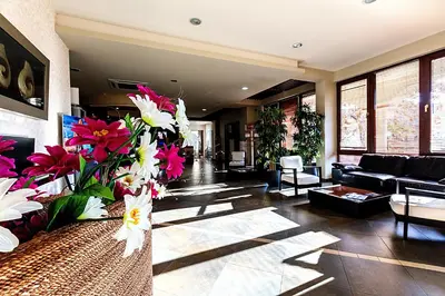 a living room with a vase filled with flowers at Primoretz Grand Hotel & Spa in Burgas City