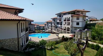 an apartment complex with a swimming pool and buildings at Arena 65m2 - 1 bedroom, 1st line to the beach in Sveti Vlas
