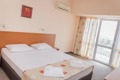 a bedroom with a large bed and a window at Hotel Eva in Ravda