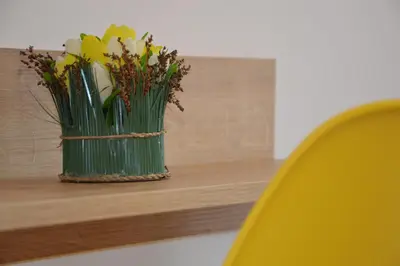 a vase of flowers sitting on a wooden shelf at Villa Valentines in Kiten
