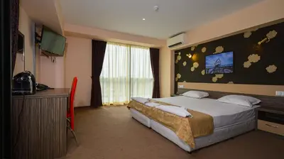 a hotel room with a bed and a television at Hotel City in Burgas City
