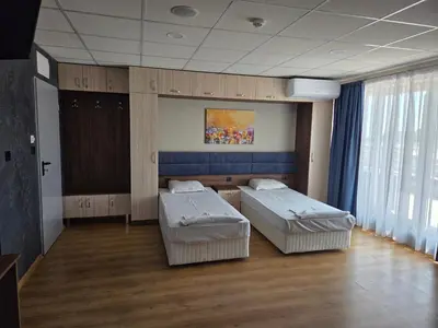 a hospital room with two beds and a painting on the wall at Hotel City in Burgas City