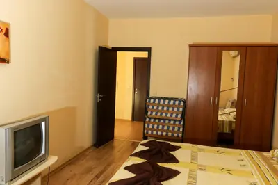a bedroom with a bed and a tv and a chair at Complex Sozopol Dreams BMT in Sozopol