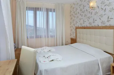 a bedroom with a bed with white towels on it at Relax Holiday Complex & Spa in Sunny Beach
