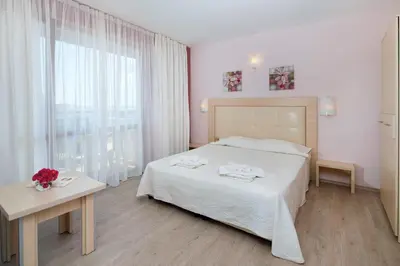 a bedroom with a bed and a table and a window at Relax Holiday Complex & Spa in Sunny Beach