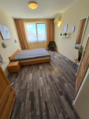 a bedroom with a bed and a wooden floor at Apartment Konstantin in Trakia Plaza in Sunny Beach