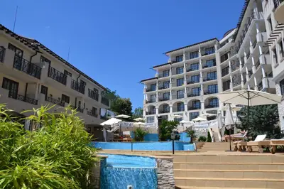 a hotel with a swimming pool in front of a building at Apartment on the Cliff Obzor in Obzor
