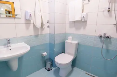 a bathroom with a toilet and a sink at Hotel Color in Varna City