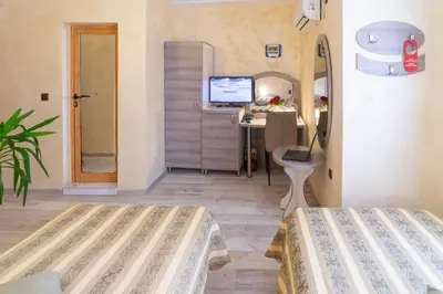 a bedroom with a bed and a desk with a computer at Hotel Color in Varna City