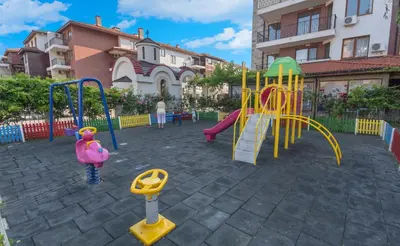 a playground with a slide and a play structure at Apollon Apartments in Nesebar