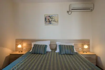 a bedroom with a bed with two pillows at Семеен хотел Бриз in Sozopol