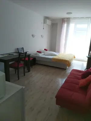 a living room with a couch and a bed and a table at Apartament Janet in Pomorie