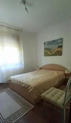 a bedroom with a bed and a chair and a window at Tanja in Sveti Vlas