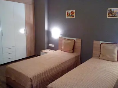 a bedroom with two beds and a cabinet at Byala Relax Apartments in Byala