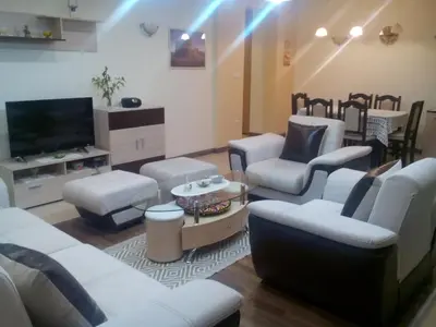 a living room with white furniture and a flat screen tv at Byala Relax Apartments in Byala