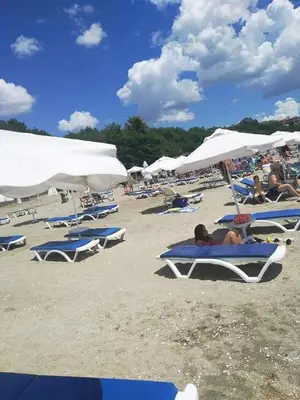 a group of people laying on chairs on a beach at Belchevi Apartments in Burgas City
