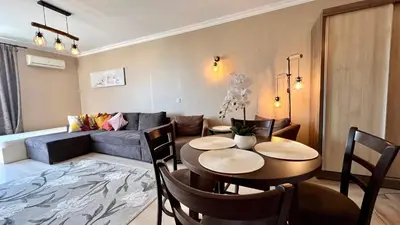 a living room with a table and chairs and a couch at Bratanov Asteria Family in Sunny Beach