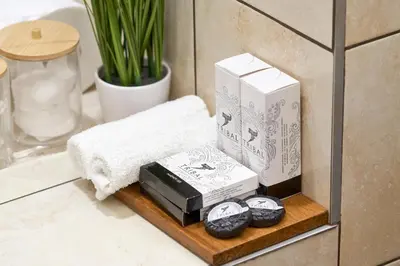 a shelf in a bathroom with towels and a clock at City Boutique Inn in Varna City