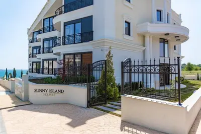 a large white house with a black fence at Apartments in Complex Sunny Island Deluxe in Chernomorets