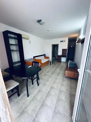 a living room with a table and a couch at Stella Udacha Apartments & Studios in Sunny Beach