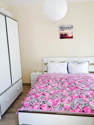 a bedroom with a large bed with pink sheets at PSB Apartments in South Bay Varna in Varna City
