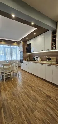 a large kitchen with white cabinets and a table and chairs at Black Sea View - Luxory apartment by the sea in Burgas City