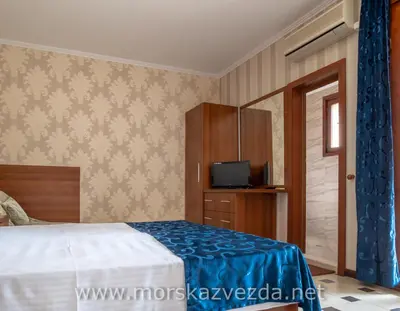 a bedroom with a bed and a tv on the wall at Hotel Morska Zvezda in Sozopol