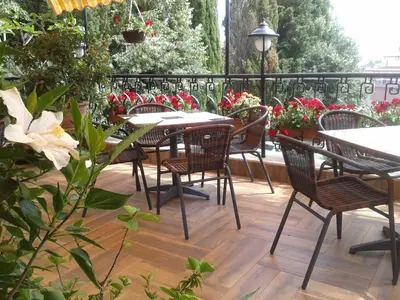 an outdoor patio with tables and chairs and flowers at Hotel Morska Zvezda in Sozopol