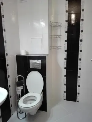 a bathroom with a white toilet and a sink at Апартамент Дарко in Pomorie