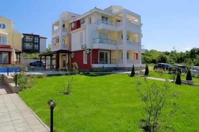 a large apartment building with a green yard at St. Stefan Villas & Hotel in Sozopol