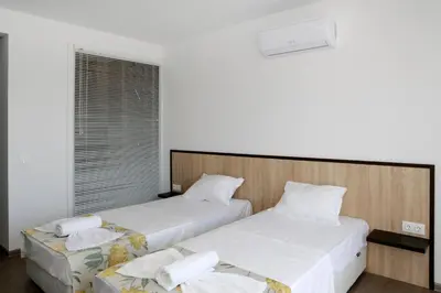 a bedroom with two beds and a window at St. Stefan Villas & Hotel in Sozopol