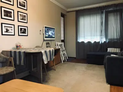 a living room with a table and a couch at Apartament Odesos in Varna City