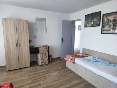 a bedroom with a bed and a desk in it at Jacky's House in Chernomorets