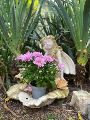 a statue of a girl sitting next to flowers at Jacky's House in Chernomorets