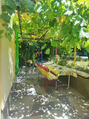 a table and a bench in a garden at Jacky's House in Chernomorets