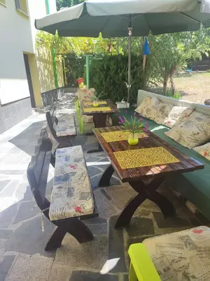 a patio with tables and chairs and an umbrella at Jacky's House in Chernomorets