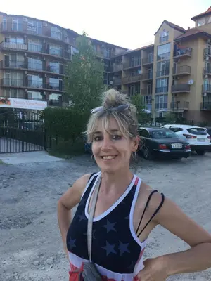 a woman standing in front of a parking lot at Sanny view South- Студия Мир авангарда in Sunny Beach
