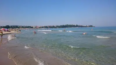a beach with a bunch of people in the water at Club Priz in Primorsko